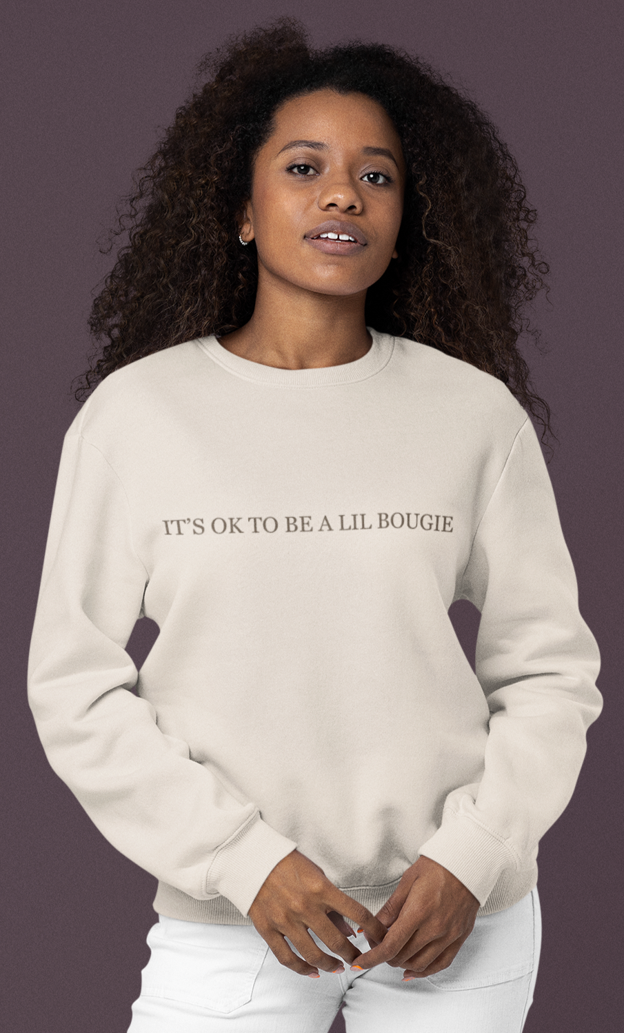 Model wearing cream Bougie crewneck sweatshirt with “It’s OK to Be a Lil Bougie” printed across the chest.