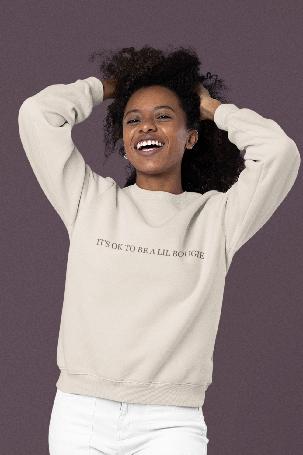 Model wearing cream Bougie crewneck with “It’s OK to Be a Lil Bougie” printed across front.