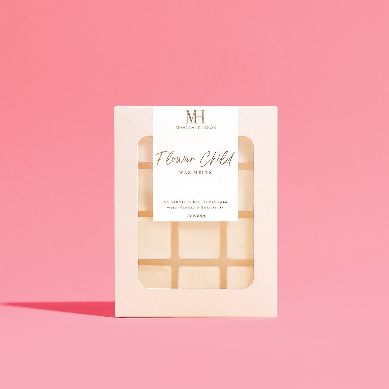 Mahogany House Flower Child Wax Melts displayed at a wide angle on a pink backdrop, highlighting the grid of wax squares inside the packaging.