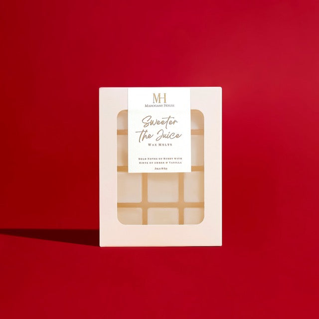 Sweeter The Juice black cherry wax melts in white clamshell packaging against a rich red background.