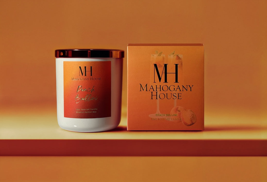 Peach Bellini 10oz wooden wick candle in white glass vessel with Mahogany House packaging, displayed on an orange background.