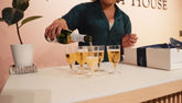 Person pouring champagne into glasses prior to a champagne toast at a candle making class.