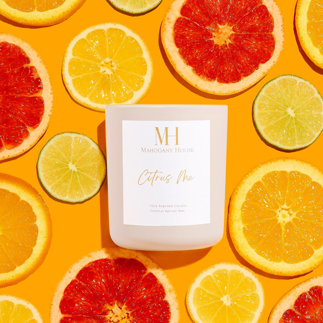 Mahogany House Citrus Me Candle styled with vibrant grapefruit, orange, and lime slices. This hand-poured coconut wax candle with a crackling wood wick features fresh and zesty citrus scents for a bright and uplifting ambiance